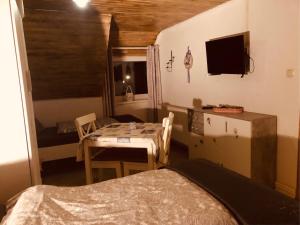 a bedroom with a table and a bed and a television at Pension Nazli Lübeck in Lübeck