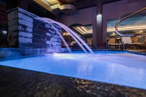 a swimming pool with a water feature in a hotel at Q Resort and Spa in Săcele +23 photos