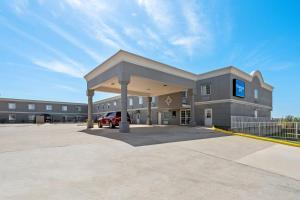 a building with a car parked in a parking lot at Rodeway Inn in Temple
