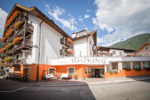 a building with a sign that reads hotel jour turning at Hotel Touring in Predazzo