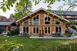 a log home with a patio and lawn at Hochfirst Waldlodge in Lenzkirch