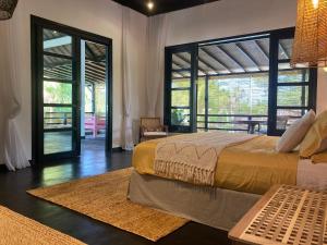 a bedroom with two beds and a large window at Villa Rawarawa Private Beachfront in Central of Lovina by GEMA MANAGEMENT BALI in Lovina