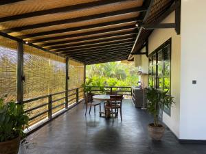 a patio with a table and chairs on a balcony at Villa Rawarawa Private Beachfront in Central of Lovina by GEMA MANAGEMENT BALI in Lovina +31 photos