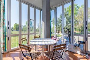 a room with a table and chairs and windows at Natura e Golf con giardino privato in Fiano
