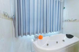 a white sink in a bathroom with a shower curtain at Hotel Nhu Loan in Bạch Ðoài
