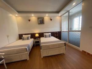 a hotel room with two beds and a window at Hotel Nhu Loan in Bạch Ðoài