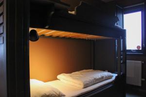 a bedroom with a bunk bed with white sheets at Stølstunets samlingssted in Beitostøl
