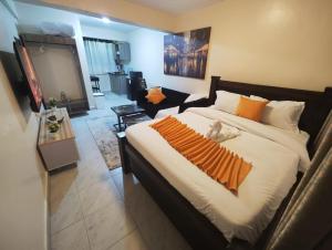 a bedroom with a large bed with a cat laying on it at Staycation by Winnie-NAIPOSHA STUDIOS in Naivasha