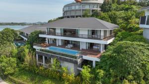 an aerial view of a house with a swimming pool at Riahi Villas by Swiss-Belhotel, Nirup Island in Belakangpandang