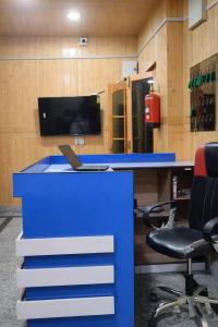 an office with a blue desk with a laptop on it at The Ladakh Residency Kargil in Kargil