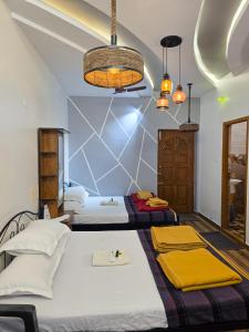 a bedroom with two beds and a ceiling at Chithralaya Guest House in Yercaud