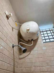 a white inhaler is attached to the wall of a room at Chithralaya Guest House in Yercaud +45 photos