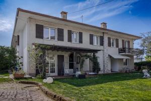 a house with black shutters and a yard at Casa Fenice in Romano D'Ezzelino
