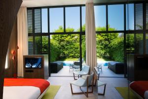 a bedroom with a bed and a large window at Sezz Saint-Tropez in Saint-Tropez