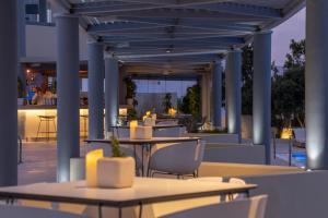 a patio with tables and chairs and a bar at The Majestic Hotel in Fira