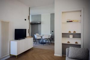a living room with a tv and a table with chairs at Casa Fenice in Romano D'Ezzelino