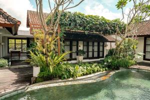 a house with a swimming pool in front of it at Goya Courtyard Ubud in Ubud