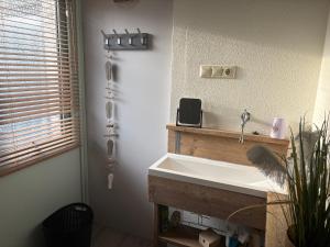 a bathroom with a white sink and a window at Waves in De Koog