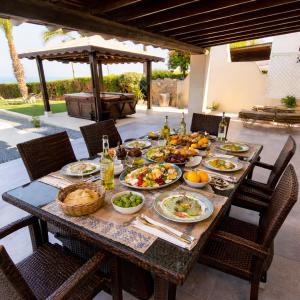 a table with plates of food on a patio at Beach Shack in Khlorakas