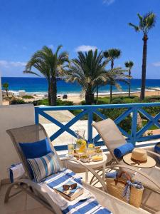 a table and chairs on a balcony with the beach at Beach Shack in Khlorakas