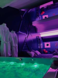 a room with purple and green lighting and a tub at Suite craz'in Love Room, jacuzzi, cinéma, climatisation, parking in Beaucaire