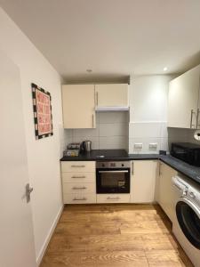 a kitchen with white cabinets and a dishwasher at Literally Central Brighton Sleeps 8 in Brighton & Hove +7 photos