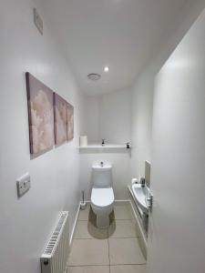 a white bathroom with a toilet and a sink at Literally Central Brighton Sleeps 8 in Brighton & Hove
