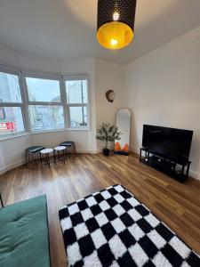 a living room with a flat screen tv and a piano at Literally Central Brighton Sleeps 8 in Brighton & Hove