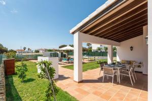 a patio of a house with a table and chairs at Villa Vientosol by Villa Plus in Cala en Forcat