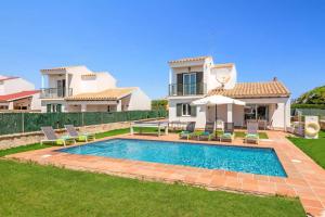 a villa with a swimming pool in front of a house at Villa Vientosol by Villa Plus in Cala en Forcat