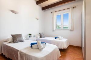 two beds in a room with a window at Villa Vientosol by Villa Plus in Cala en Forcat +20 photos