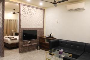 a living room with a couch and a television at Amar Resorrt in Motīhāri