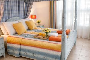 a bedroom with a bed with a tray of food on it at Beach Shack in Khlorakas +16 photos