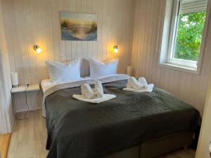 a bedroom with a large bed with towels on it at Ferienhaus Strandpark 13 in Grömitz +2 photos