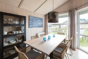a dining room with a table and chairs at Ferienhaus Strandpark 41 in Grömitz +11 photos