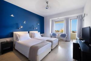 a hotel room with a bed and a television at The Majestic Hotel in Fira
