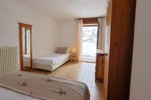 a bedroom with a bed and a window with a bed and a bed sqor at Rifugio Baita Belvedere in Champoluc +49 photos