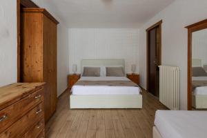 a bedroom with a white bed and wooden floors at Rifugio Baita Belvedere in Champoluc