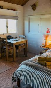 a bedroom with a desk and a bed and a table at Cwt Gafr Bach in Pwllheli