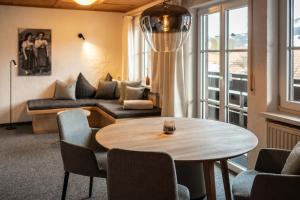 a living room with a table and chairs and a couch at Das Tannacker - Ferienwohnungen Hartmann in Fischen