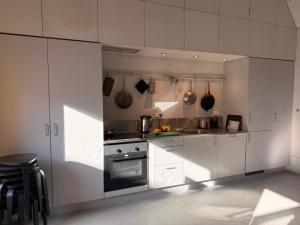 a kitchen with white cabinets and a stove at 44Møen in Askeby