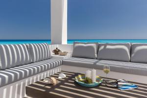 a living room with a couch and a glass of wine at Belvedere Beachfront Villa in Afantou