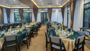 a conference room with tables and chairs and windows at Balishira Resort Ltd. in Sreemangal