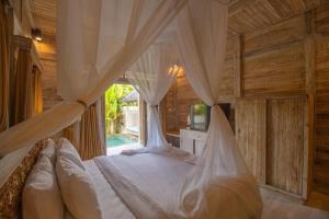 a bedroom with a bed with a mosquito net at Wana Shanti Villa in Bringkit