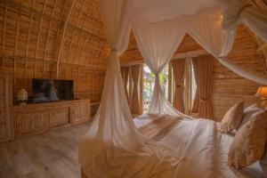 a bedroom with a bed with a mosquito net at Wana Shanti Villa in Bringkit +33 photos