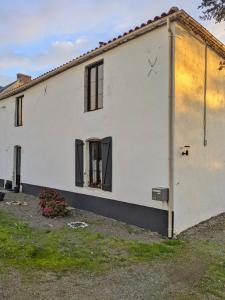 a white house with black windows at chambre chez hote familiale 2, 4, 5,6 in Mareuil-sur-Lay