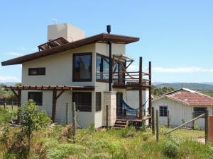 a house with a porch and a playground at Casa Viva in Imbituba