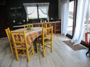 a kitchen with a wooden table with yellow chairs at Casa Viva in Imbituba