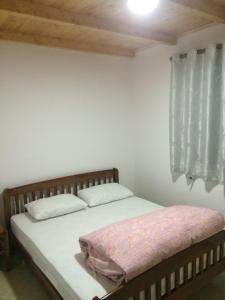 a bed with two pillows and a window in a room at Buni Shqipes in Theth