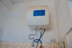 a urinal in a bathroom with a hose at Fido's Guesthouse in Ruhengeri